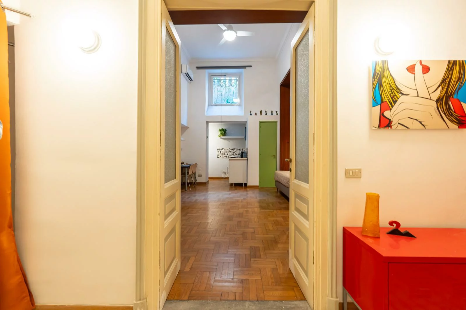 Corridoio interno con porte aperte e parquet a spina di pesce