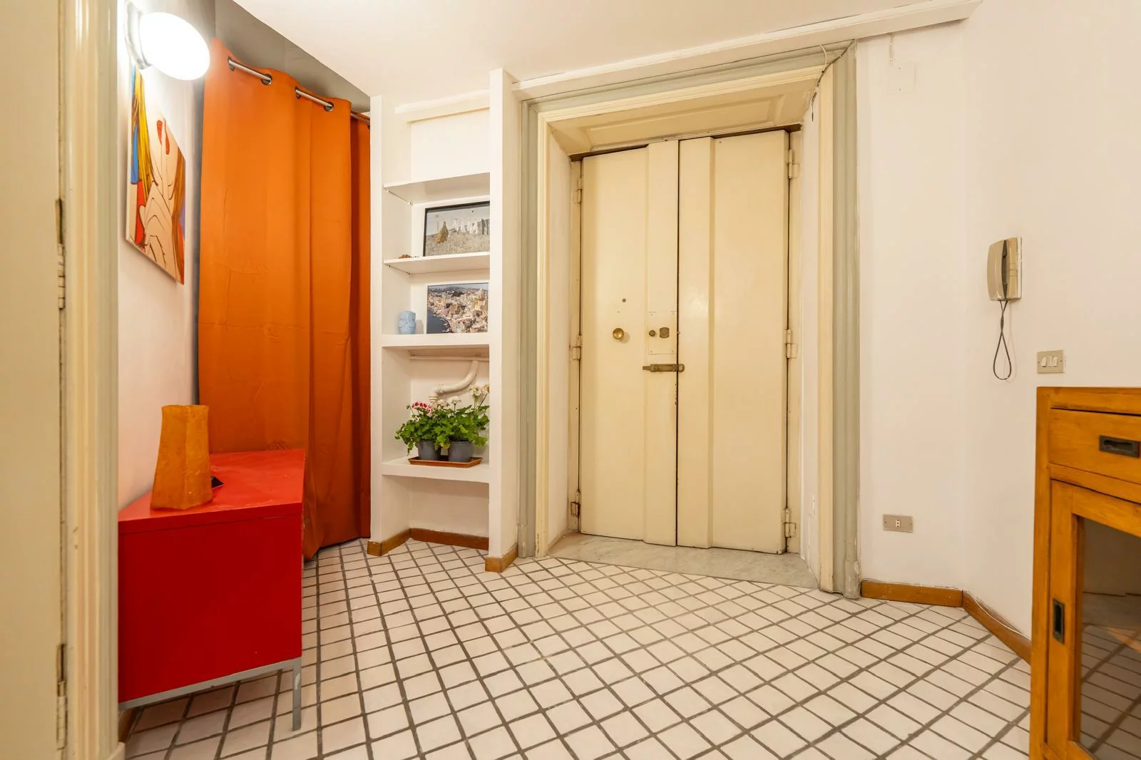 Ingresso della Suite della Nonna con porta d'epoca e pavimento a piastrelle bianche