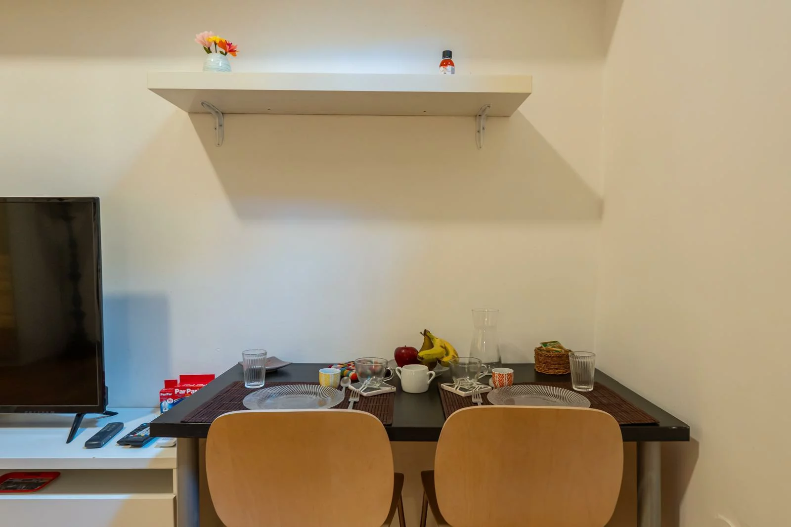 Zona pranzo con tavolo apparecchiato e mensola con piccoli vasi